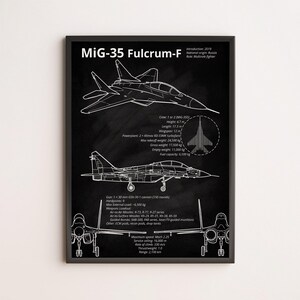 May include: A black framed print with a white line drawing of a MiG-35 Fulcrum-F fighter jet. The print includes technical specifications, including height, length, and armament. The text "MiG-35 Fulcrum-F" is displayed prominently.