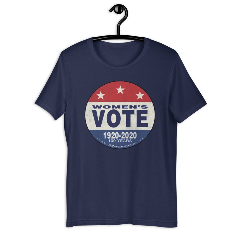 May include: Navy blue t-shirt with a red, white, and blue circular graphic that says "Women's Vote 1920-2020 100 Years 19th Amendment".