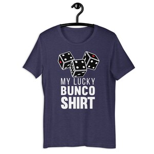 May include: A navy blue t-shirt with a white graphic of three dice and the text "My Lucky Bunco Shirt".