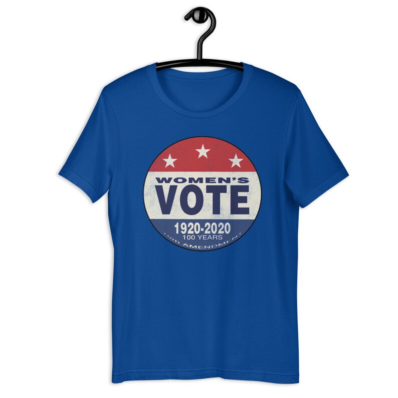 May include: A royal blue t-shirt with a vintage-style button featuring the text "Women's Vote 1920-2020 100 Years 19th Amendment" in red, white, and blue.