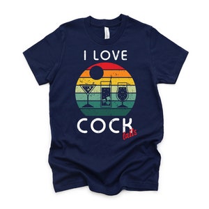 Op de afbeelding: Een marineblauw t-shirt met een vintage-stijl grafische afbeelding van drie cocktails en de tekst "Ik hou van cocktails".