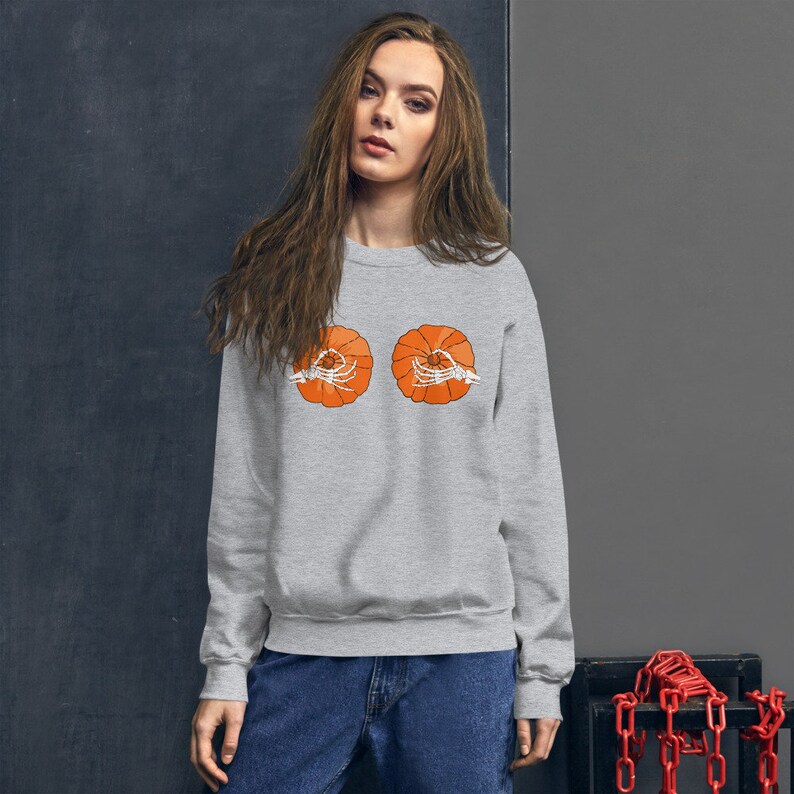 May include: A gray sweatshirt with a graphic of two orange pumpkins with skeleton hands holding them.