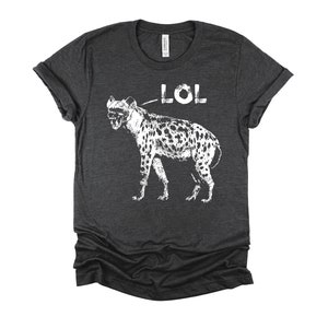 May include: A dark heather grey t-shirt with a white graphic of a hyena with the word "LOL" above it.