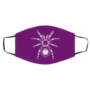 K&ouml;nnte beinhalten: Eine violette Gesichtsmaske mit einer wei&szlig;en Illustration einer Vogelspinne. Die Spinne ist mittig auf der Maske platziert, mit deutlich definierten Beinen und K&ouml;rper. Die Maske hat schwarze Ohrschlaufen.