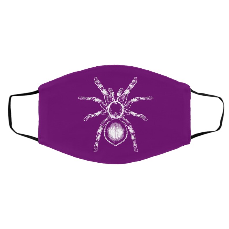 K&ouml;nnte beinhalten: Eine violette Gesichtsmaske mit einer wei&szlig;en Illustration einer Vogelspinne. Die Spinne ist mittig auf der Maske platziert, mit deutlich definierten Beinen und K&ouml;rper. Die Maske hat schwarze Ohrschlaufen.