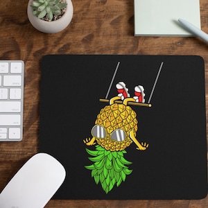 May include: A black mouse pad with a pineapple wearing sunglasses and red shoes hanging from a swing set. The pineapple has green leaves and a yellow body.