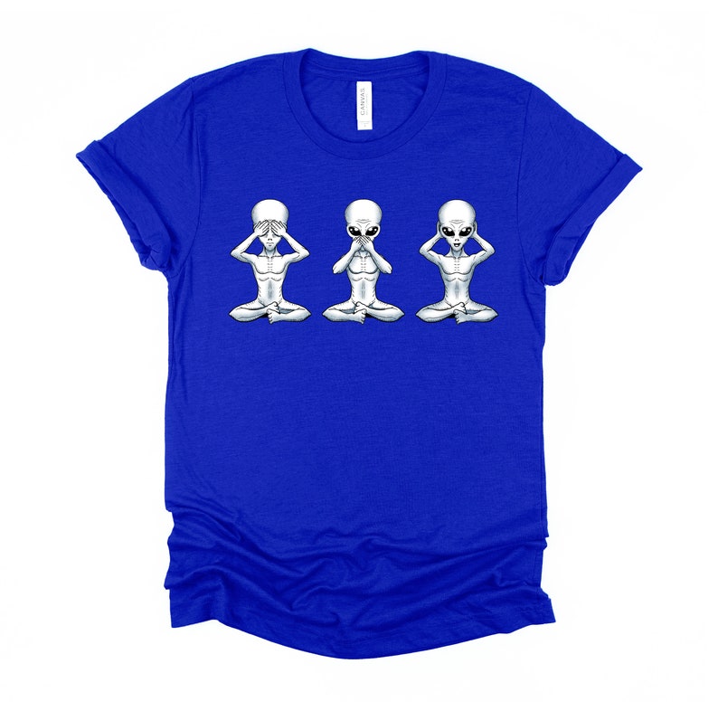 May include: A royal blue t-shirt featuring a graphic of three grey aliens in a 'see no evil, hear no evil, speak no evil' pose.