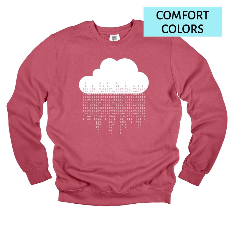 Op de afbeelding: Een roze sweatshirt met ronde hals. De voorkant heeft een witte wolk met binaire code die naar beneden 'regent'. In de rechterbovenhoek staat in een lichtblauwe rechthoek de tekst "COMFORT COLORS" in het wit.