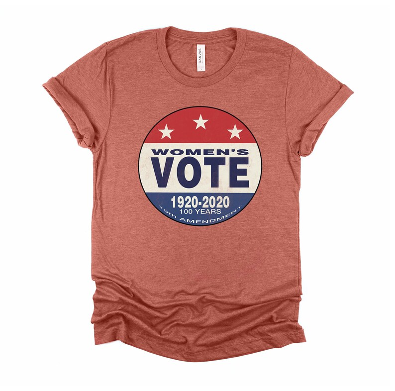 May include: A red heather t-shirt with a blue and red circular graphic that says "Women's Vote 1920-2020 100 Years 19th Amendment".