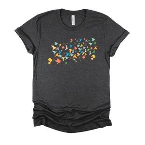 May include: A dark heather grey t-shirt with a design of colorful origami birds flying in a flock.