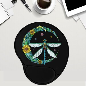 May include: A black mouse pad with a peace sign design featuring a blue dragonfly surrounded by colorful flowers and leaves.