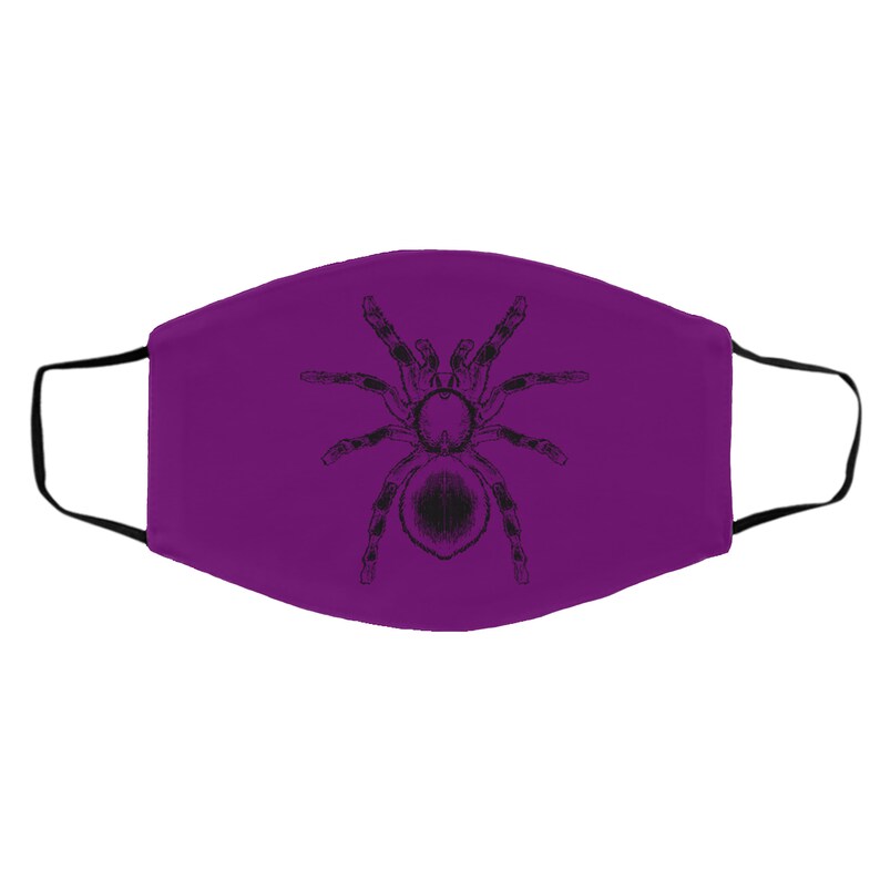K&ouml;nnte beinhalten: Eine violette Gesichtsmaske mit einer schwarzen Illustration einer Tarantel. Die Maske hat schwarze Ohrschlaufen und besteht aus einem weichen Stoff. Das Tarantel-Design ist detailliert und mittig auf der Maske platziert.