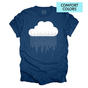 Pode incluir: Camiseta azul marinho com um desenho de nuvem branca e c&oacute;digo bin&aacute;rio. A camiseta tem o texto "COMFORT COLORS" em um ret&acirc;ngulo azul claro. Uma camiseta confort&aacute;vel e casual para uso di&aacute;rio.