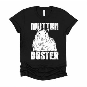 May include: Black t-shirt with a white graphic of a sheep and the text "MUTTON BUSTER" in a distressed font.