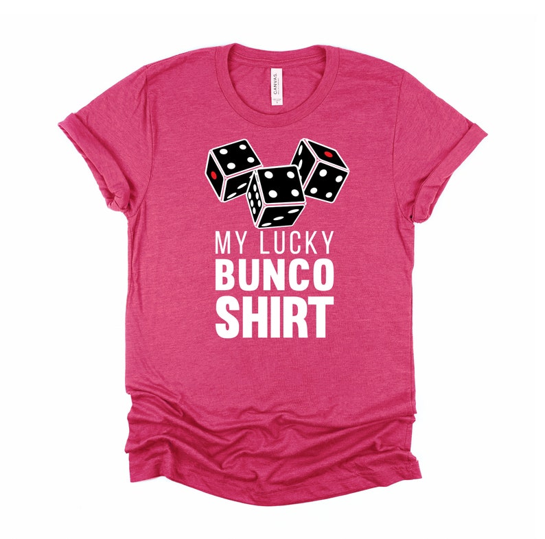 May include: Pink t-shirt with a white graphic of three dice and the text "My Lucky Bunco Shirt".