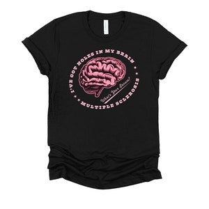 May include: Black t-shirt with a pink circle graphic featuring a brain with holes and the text "I've got holes in my brain. What's your excuse? Multiple Sclerosis."