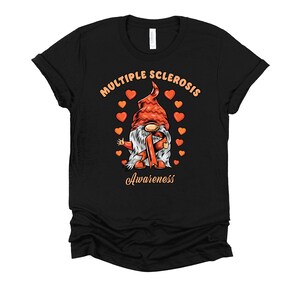 May include: Black t-shirt with a cartoon gnome wearing an orange hat and holding an orange ribbon. The text "Multiple Sclerosis Awareness" is printed on the shirt.