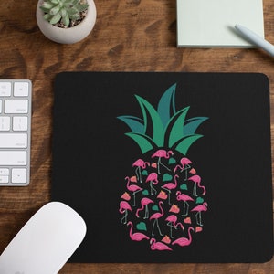May include: A black mouse pad with a green pineapple design. The pineapple is made up of pink flamingos.