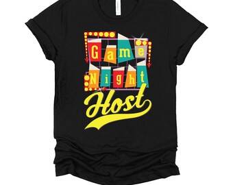 May include: Black t-shirt with a retro-style graphic that says "Game Night Host" in colorful letters and a yellow, curved font.