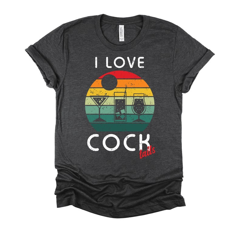 Op de afbeelding: Een donkergrijs T-shirt met een vintage-zonnenonderganggrafiek en de tekst "Ik hou van cocktails" in wit. Het woord "cocktails" is in rood.