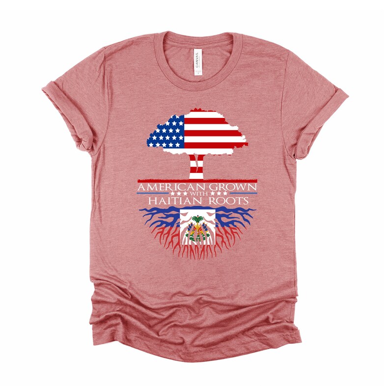 May include: A heather red t-shirt with a graphic of a tree with the American flag as the leaves and the Haitian flag as the roots. The text "AMERICAN GROWN WITH HAITIAN ROOTS" is printed on the shirt.