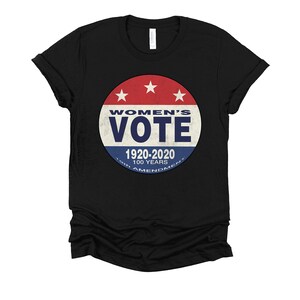 May include: Black t-shirt with a red, white, and blue button featuring the text "Women's Vote" and "1920-2020 100 Years 19th Amendment".