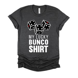 May include: A dark gray t-shirt with a white graphic of three dice and the text "My Lucky Bunco Shirt".