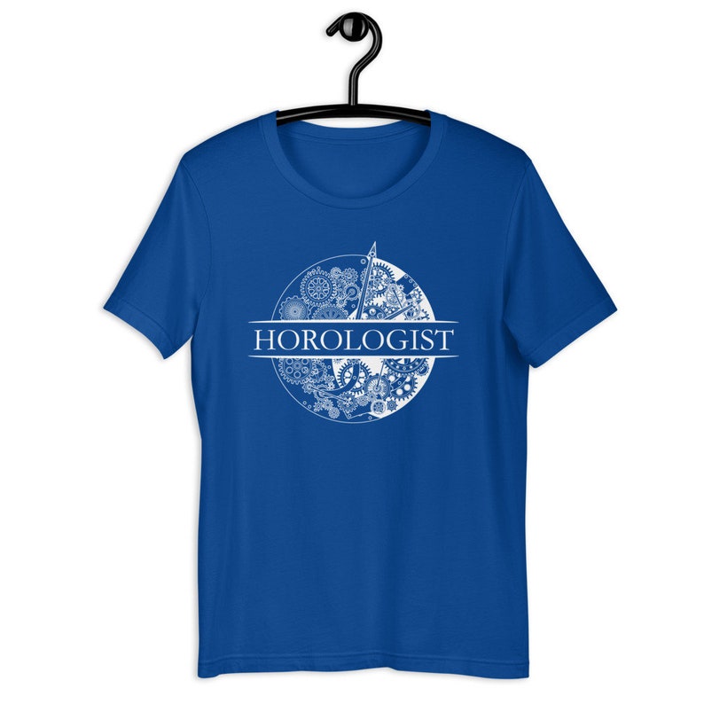 May include: Royal blue t-shirt with a white graphic of a clock face with gears and the word "HOROLOGIST" printed across the center.