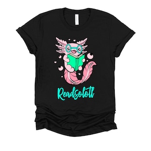 May include: Black t-shirt with a pink axolotl wearing glasses and reading a green book. The text "Readsolottl" is printed in turquoise below the axolotl.