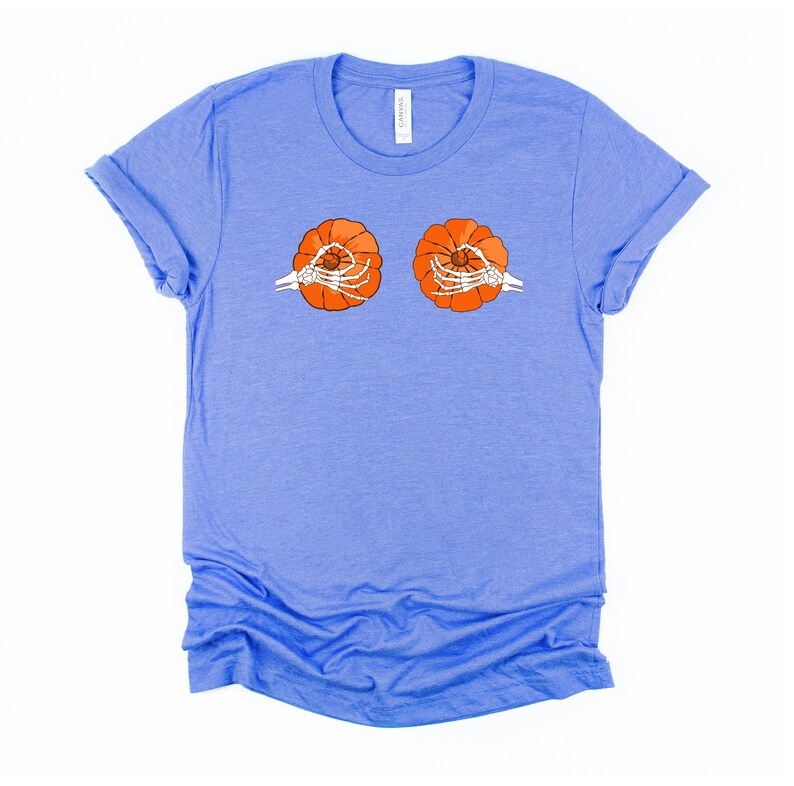 May include: A light blue t-shirt with a graphic of two orange pumpkins with skeleton hands holding them.