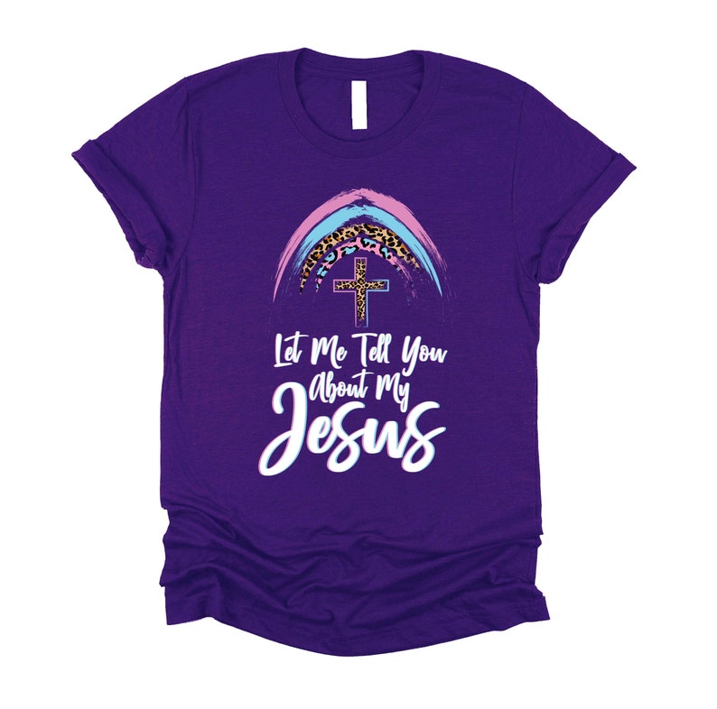 May include: Purple t-shirt with a rainbow and cross graphic. The text "Let Me Tell You About My Jesus" is printed on the shirt.