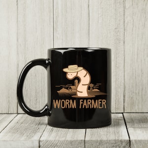 May include: Black coffee mug with a white worm wearing a straw hat and the text "WORM FARMER".