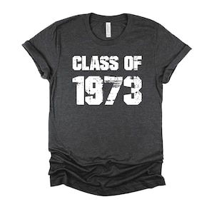May include: Dark gray t-shirt with white text that reads "Class of 1973".