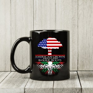 May include: Black ceramic mug with a design of a tree with an American flag for the canopy and a Basque flag for the roots. The text "American Grown with Basque Roots" is printed on the mug.