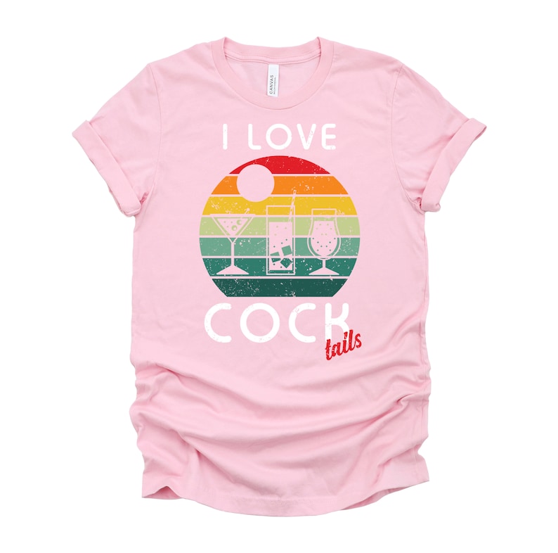 Op de afbeelding: Roze T-shirt met een retro zonsondergang-afbeelding en de tekst "Ik hou van cocktails" in wit. De afbeelding toont drie verschillende cocktailglazen.