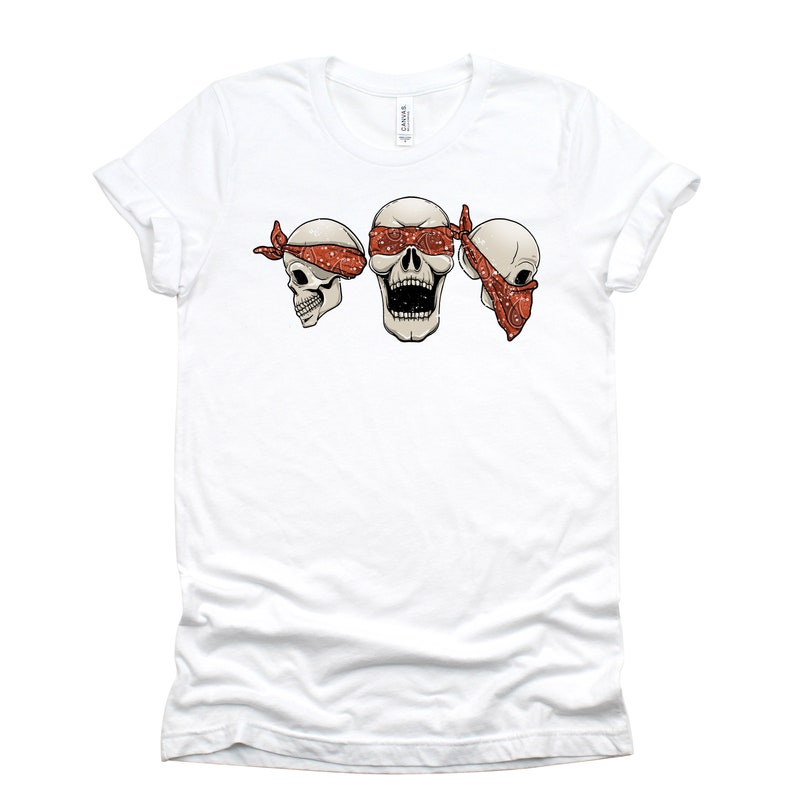 May include: White t-shirt with a graphic of three cartoon skulls wearing red bandanas. The skull in the middle has a bandana covering its eyes.