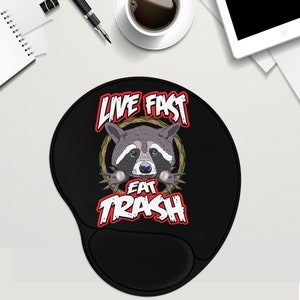 May include: Black mouse pad with a raccoon illustration and the text "Live Fast Eat Trash" in red and white.