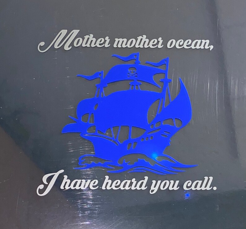 May include: A blue silhouette of a pirate ship with a skull and crossbones on the sail. The text "Mother mother ocean, I have heard you call." is written in white on a black background.