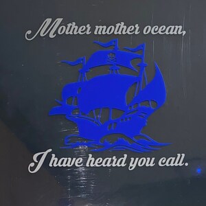 May include: A blue silhouette of a pirate ship with a skull and crossbones on the sail. The text "Mother mother ocean, I have heard you call." is written in white below the ship.