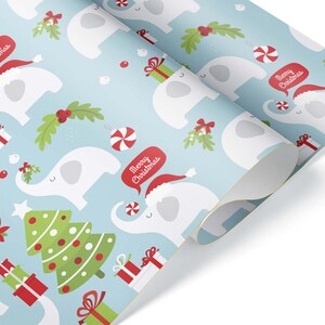 May include: Light blue Christmas-themed wrapping paper with a repeating pattern of white elephants wearing Santa hats, Christmas trees, and gift boxes. The elephants have speech bubbles that say "Merry Christmas". Candy canes and mistletoe are also featured.