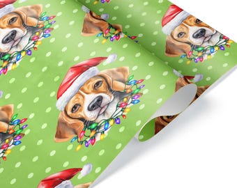 Può includere: Carta da regalo con un motivo ripetuto di un cane beagle che indossa un cappello da Babbo Natale rosso e bianco, con una fila di luci natalizie colorate attorno al collo, su uno sfondo verde chiaro con pois bianchi.