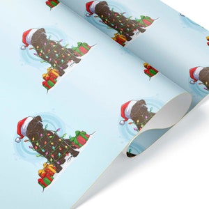 May include: Light blue wrapping paper featuring a repeating pattern of a brown dog wearing a Santa hat and Christmas lights. The dog is surrounded by wrapped gifts. The paper is rolled up, showing the pattern.