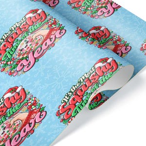 May include: Light blue wrapping paper featuring a repeating pattern of a cartoon character with a Santa hat and the text It's the Most Squishy Time of the Year. The design includes candy canes, holly, and white snowflake outlines on the background.