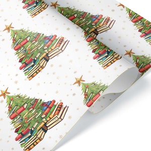 May include: White wrapping paper with a repeating pattern of Christmas trees made of stacked books. The trees are decorated with a star on top and have a green base. The background is white with gold snowflakes.