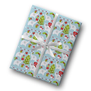 May include: A wrapped gift with light blue wrapping paper featuring a pattern of white elephants, Christmas trees, and presents. The gift is tied with a white ribbon. The wrapping paper also has the text "Merry Christmas".