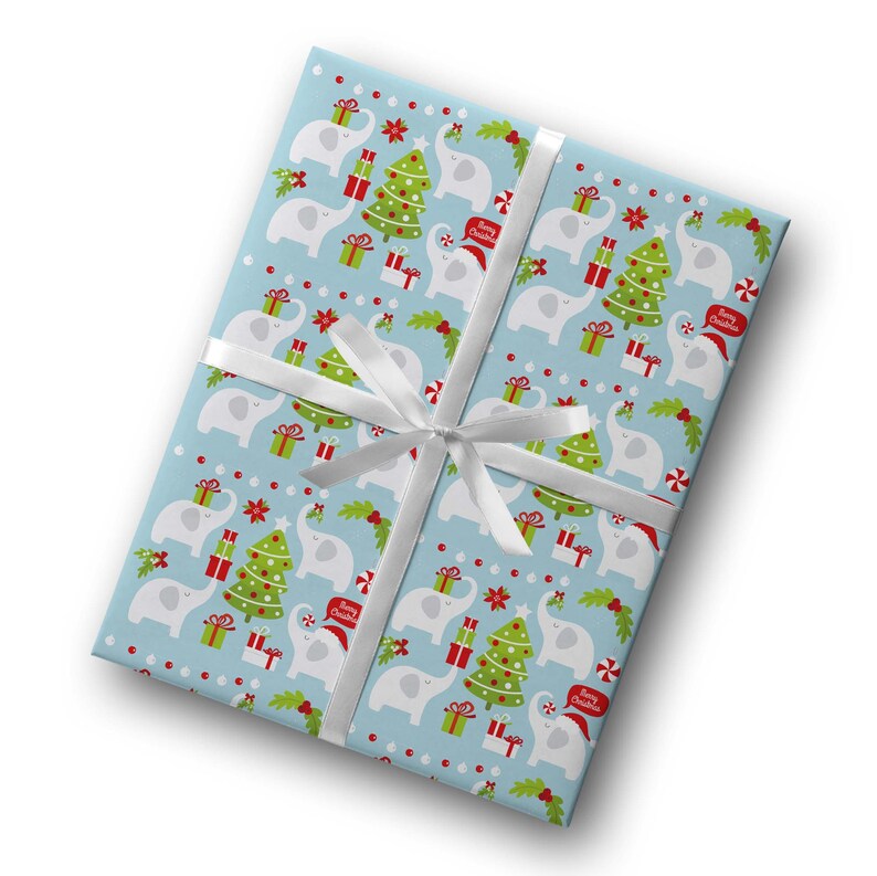May include: A wrapped gift with light blue wrapping paper featuring a pattern of white elephants, Christmas trees, and presents. The gift is tied with a white ribbon. The wrapping paper also has the text "Merry Christmas".