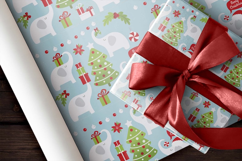 May include: Christmas-themed wrapping paper and a wrapped gift with a red satin bow. The wrapping paper features a light blue background with white elephants, Christmas trees, and gift boxes. The gift box is wrapped in the same paper.