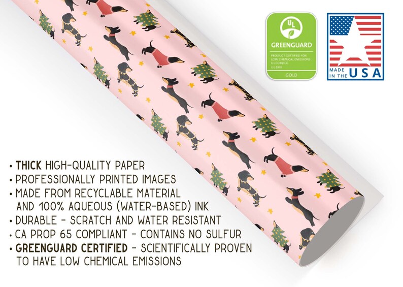 Op de afbeelding: Roze inpakpapier met een herhalend patroon van zwarte en bruine teckels die rode truien dragen en kerstboompjes vasthouden. Het papier is gemaakt van recyclebaar materiaal en is GreenGuard-gecertificeerd.