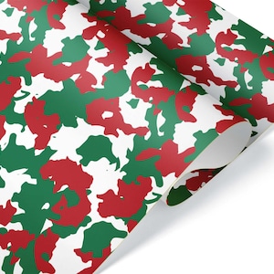 May include: A roll of wrapping paper with a camouflage pattern in red, green, and white. The paper is partially unrolled, revealing the underside. The design features irregular shapes, creating a festive, holiday-themed look.