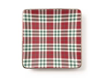 May include: A square ceramic dish featuring a red, white, and dark green plaid pattern. The dish has a smooth, glossy finish and a thin metallic gold-toned rim that outlines the square shape, providing a clean and defined edge to the design.